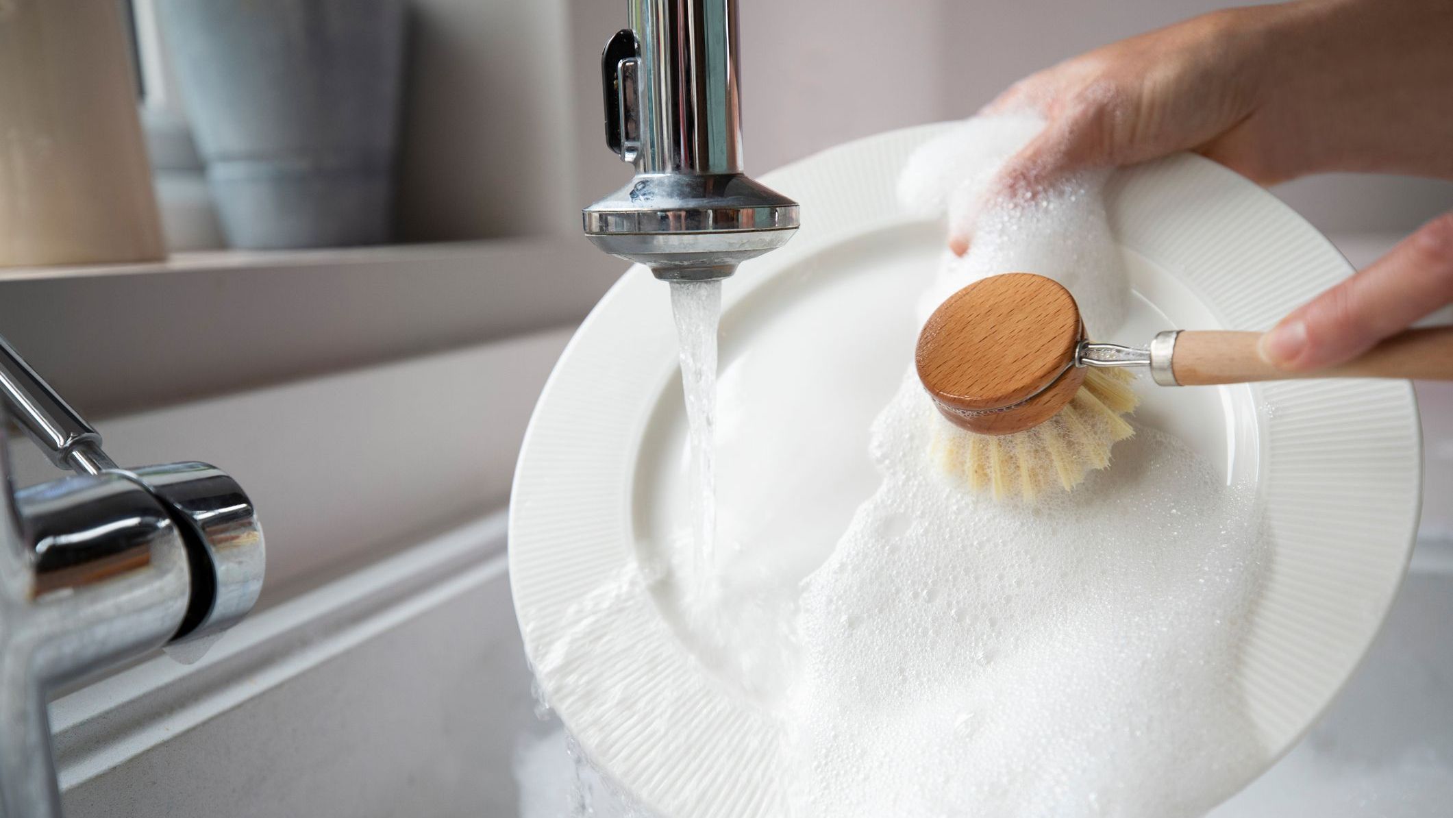 Een bord met de hand afwassen met afwasmiddel